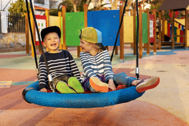 istock cheerful children having fun in playground basket swing 1387517073
