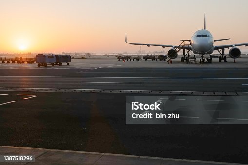 istock The plane in front of the airport terminal at sunrise 1387518296