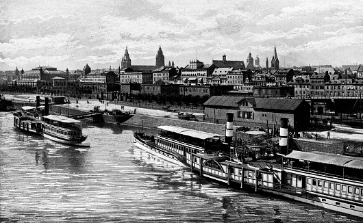 Steam paddlewheel boats docked at the Port of Mainz in the city of Mainz in Rhineland-Palatinate, Germany. Vintage halftone etching circa 19th century.