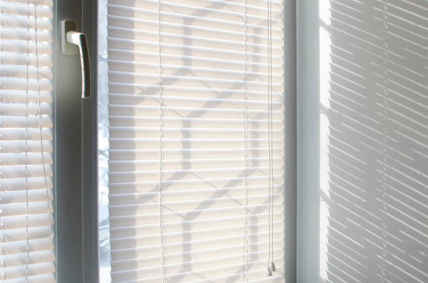 istock The light passes through the plastic blinds on the window, close-up. 1387520626