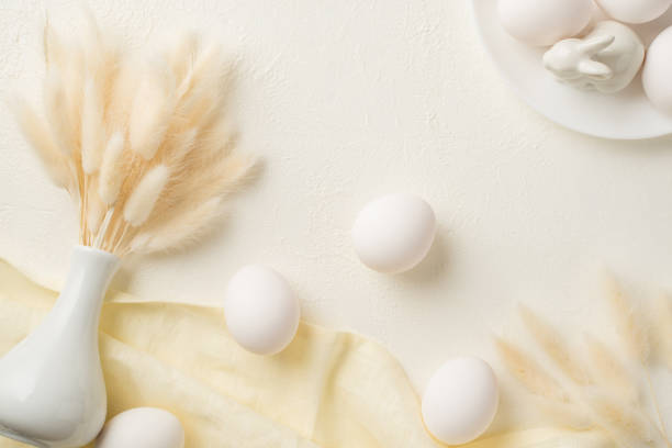 istock Top view photo of easter decorations white vase with lagurus flowers plate ceramic rabbit white easter eggs and textile on isolated white background 1387520664