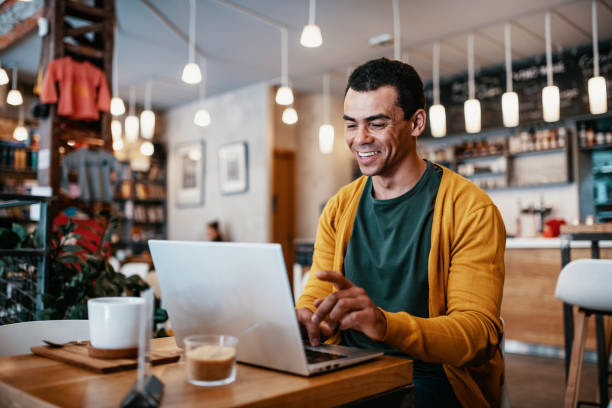 istock Mature man working remotely on laptop from cafe 1387520816