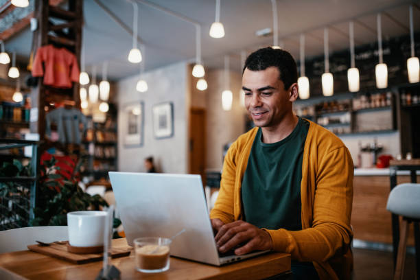 istock Mature man working remotely on laptop from cafe 1387521412