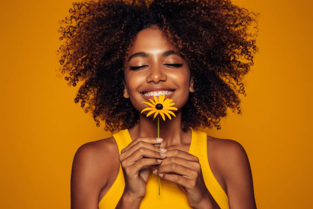 istock Beautiful afro woman with bunch of flowers 1387523607