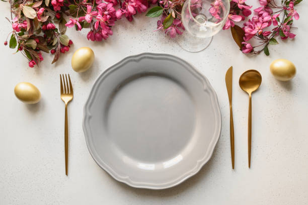 istock Easter festive dinner with golden eggs, festive tableware and flowers. 1387524726
