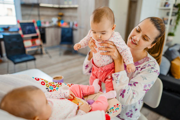 istock Young mother playing with her newborn babies 1387524982