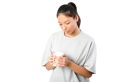 Woman holding a mug. Isolated on white background. Young asiatic woman.