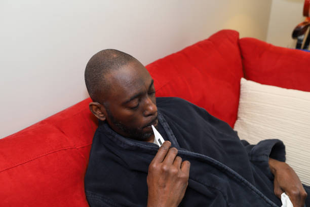 A black African-American man taking his temperature