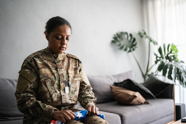 Female soldier holding the American flag at home