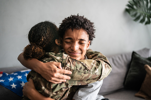 Soldier mother and son hugging each other at home