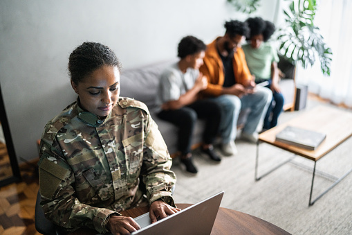 Female soldier using the laptop at home