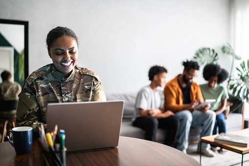 Female soldier using the laptop at home