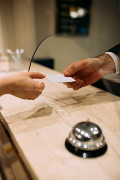 гости получают ключ-карту на стойке регистрации отеля - hotel reception bell hotel service bell стоковые фото и изображения