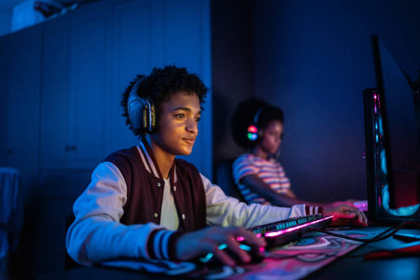 teenage boy playing on the computer at home - gamer imagens e fotografias de stock