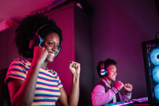 istock Young woman celebrating while playing on the computer at home 1387529418