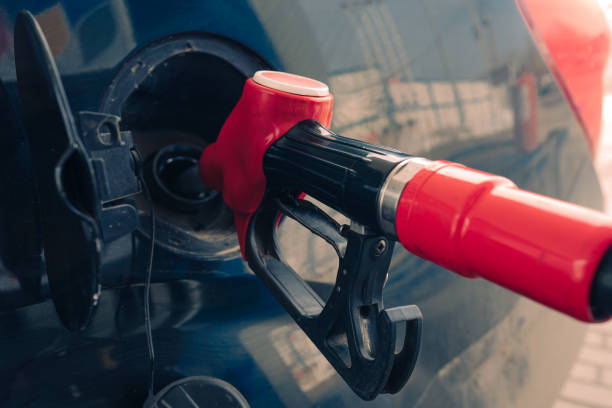 Pumping gasoline fuel nozzle to refuel stock photo