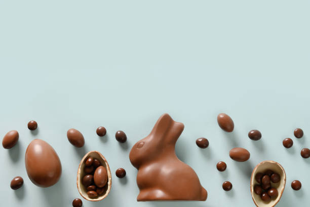 Happy Easter greeting card with chocolate sweets rabbit, eggs. Concept egg hunt. Happy Easter greeting card with chocolate sweets rabbit, eggs on blue background. Concept egg hunt. chocolate bunny stock pictures, royalty-free photos & images