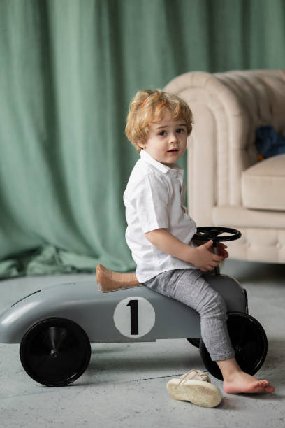 istock Little boy driving big toy car 1387531897