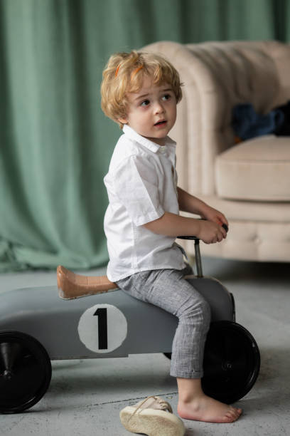 istock Little boy on a toy-car 1387531899