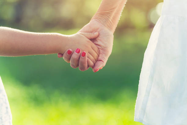 istock Grandparent holding childs hand. 1387531988