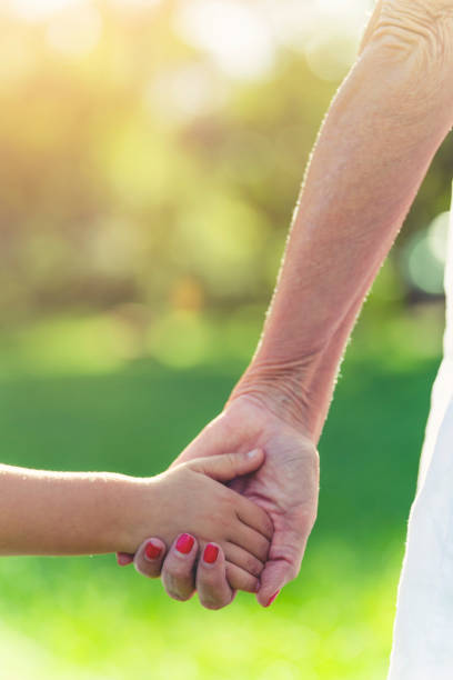 istock Grandparent holding childs hand. 1387531991