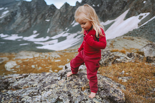 Child girl hiking barefoot in mountains travel adventure family vacations trip healthy lifestyle 3 years old kid outdoor