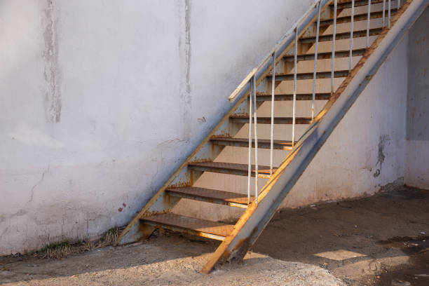 istock outdoor fire exit stair of old building. rusty fire escapes metal stair 1387535239