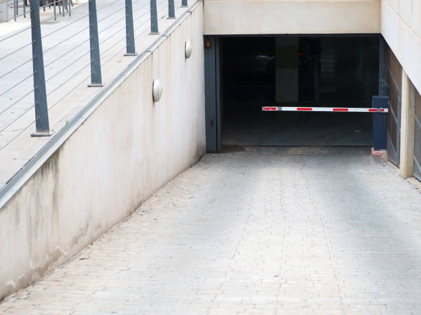 istock Subterranean car parking entrance ramp with horizontal barrier 1387535398