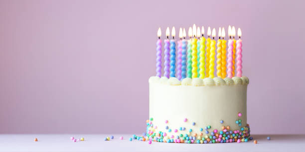 Rainbow birthday cake with candles stock photo
