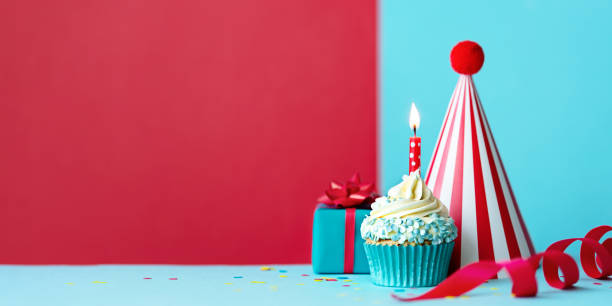 istock Birthday party background with cupcake, gift and party hat 1387535594
