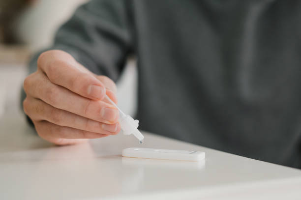 istock Crop anonymous male taking rapid COVID test at home 1387539816