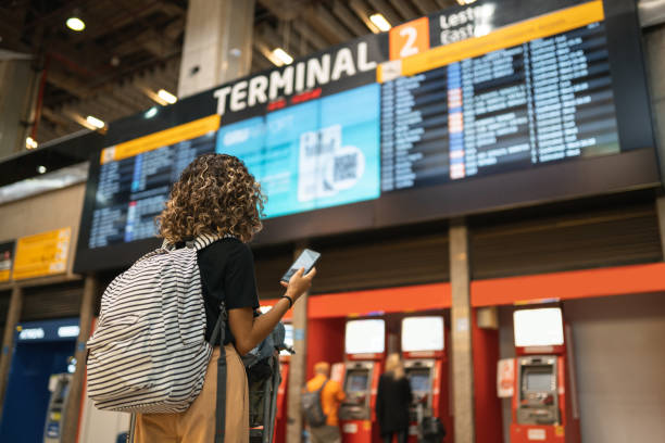tourist looking at arrivals and departures table - arrival departure board imagens e fotografias de stock