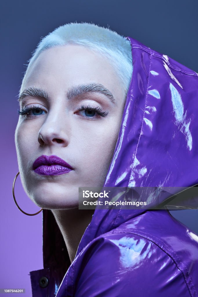 Studio shot of a beautiful woman woman wearing a purple jacket and purple lipstick Lost in the purple Rebellion Stock Photo