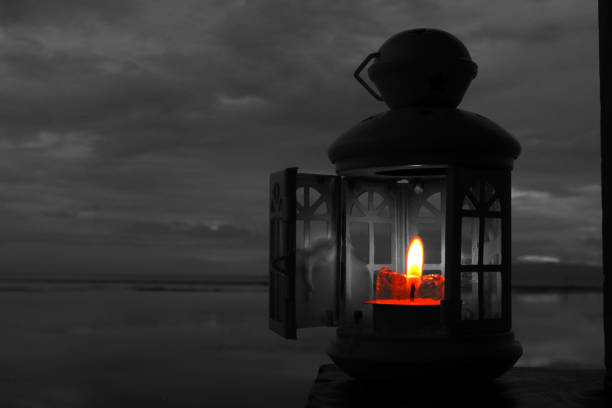 Classic lantern and candle light inside with opened window on night sky background in black and white. Inspirational and spirituality concept backgrounds.
