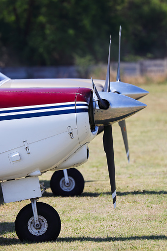 Two light recreational propeller airplanes parked in-line at small rural airport, South Africa