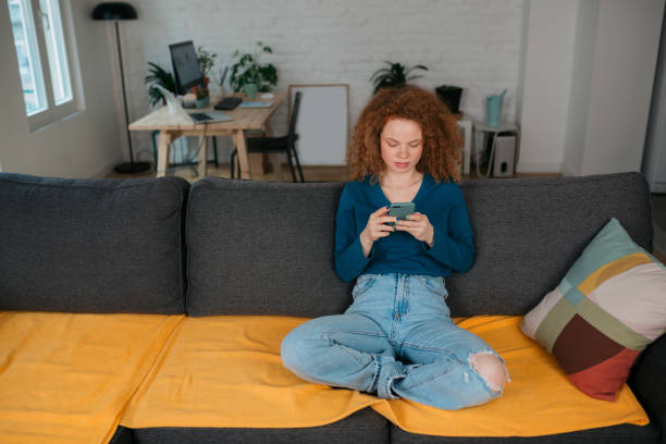 istock Young Caucasian woman using a smart phone at home 1387554222