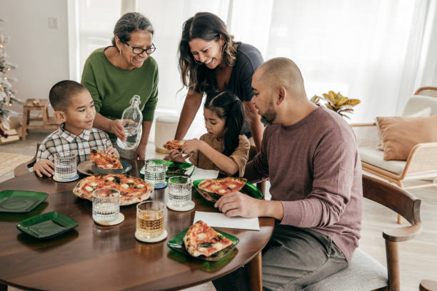 istock Multi-ethnic family having pizza for lunch 1387557088
