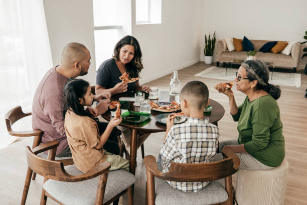 istock Multi-ethnic family having pizza for lunch 1387557090