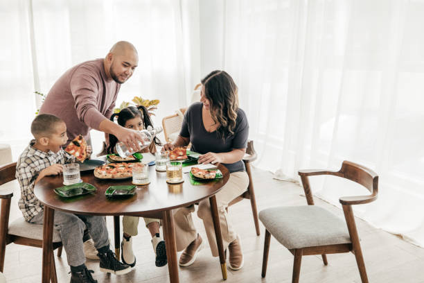 istock Multi-ethnic family having pizza for lunch 1387557101
