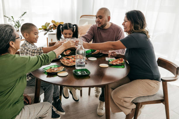 istock Multi-ethnic family having pizza for lunch 1387557103
