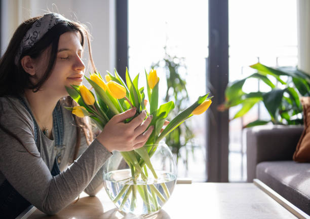 istock Woman smelling beautiful yellow tulips. 1387557277