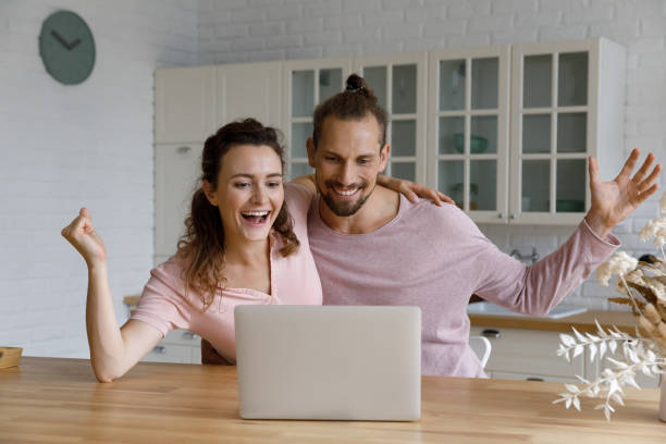istock Cheerful excited couple celebrating achieve at computer 1387557357