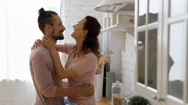 istock Happy millennial married couple in love hugging in kitchen 1387557378