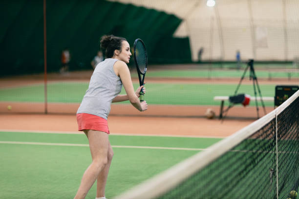 joueuse de tennis jouant à l’entraînement avec raquette et balle sur le court - indoor tennis photos et images de collection