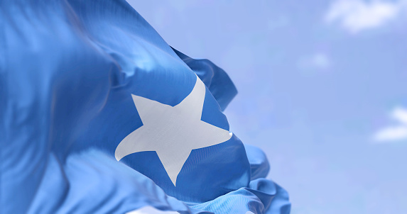 Detail of the national flag of Somalia waving in the wind on a clear day. Somalia is a country in the Horn of Africa. Selective focus.