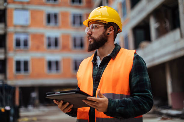 monitoring workflow from the palm of his hands - manual worker portrait helmet technology imagens e fotografias de stock