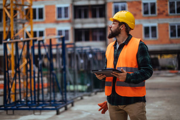 supervising the construction process - manual worker portrait helmet technology imagens e fotografias de stock