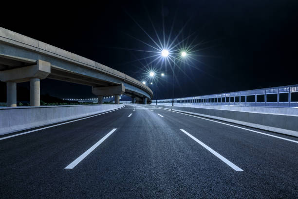 istock Asphalt road and bridge building at night 1387569631