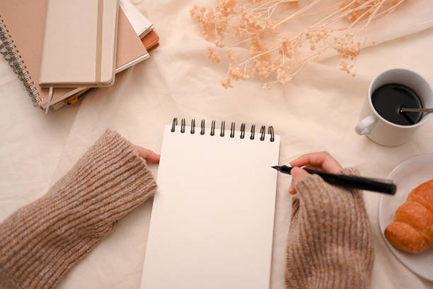 istock Close-up image, Female listing a to do lists on her spiral notepad 1387570268