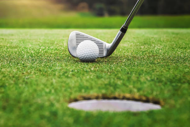 istock golf player putting golf ball into hole 1387571371